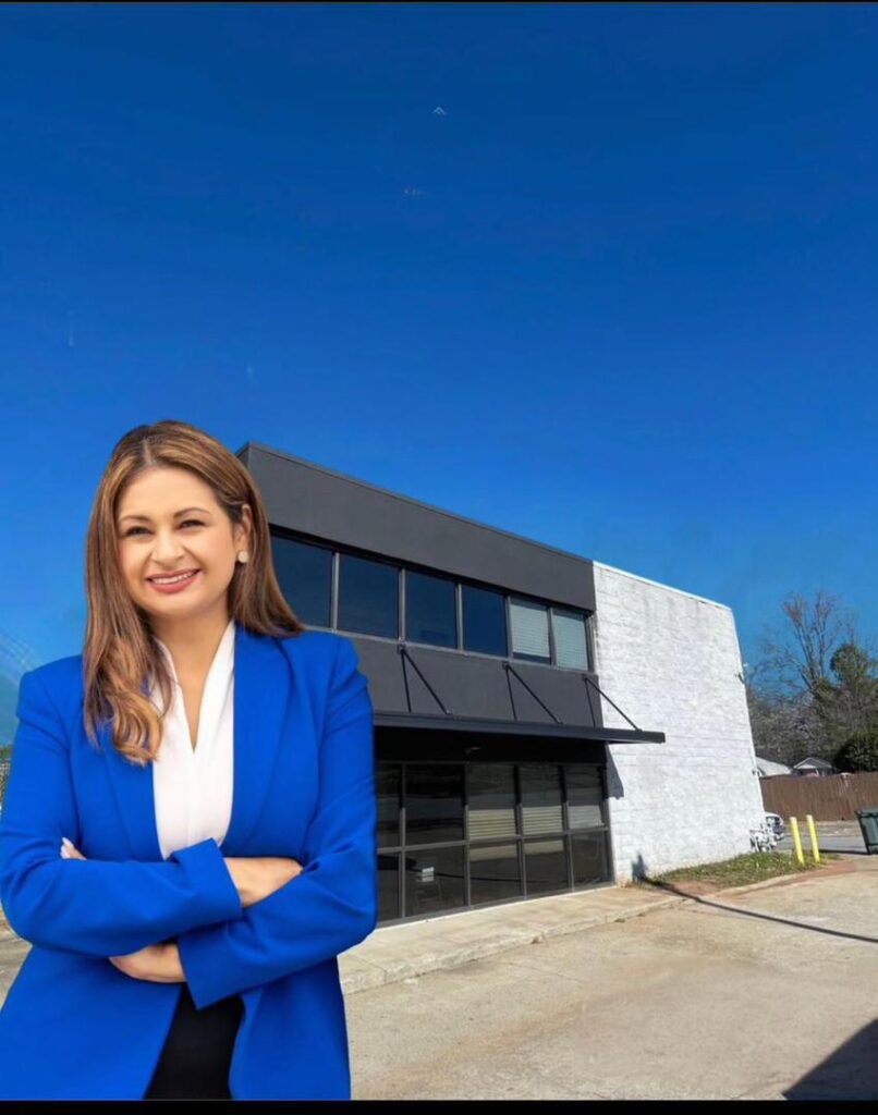 Cynthia McClure Alexander Standing in front of an office building.